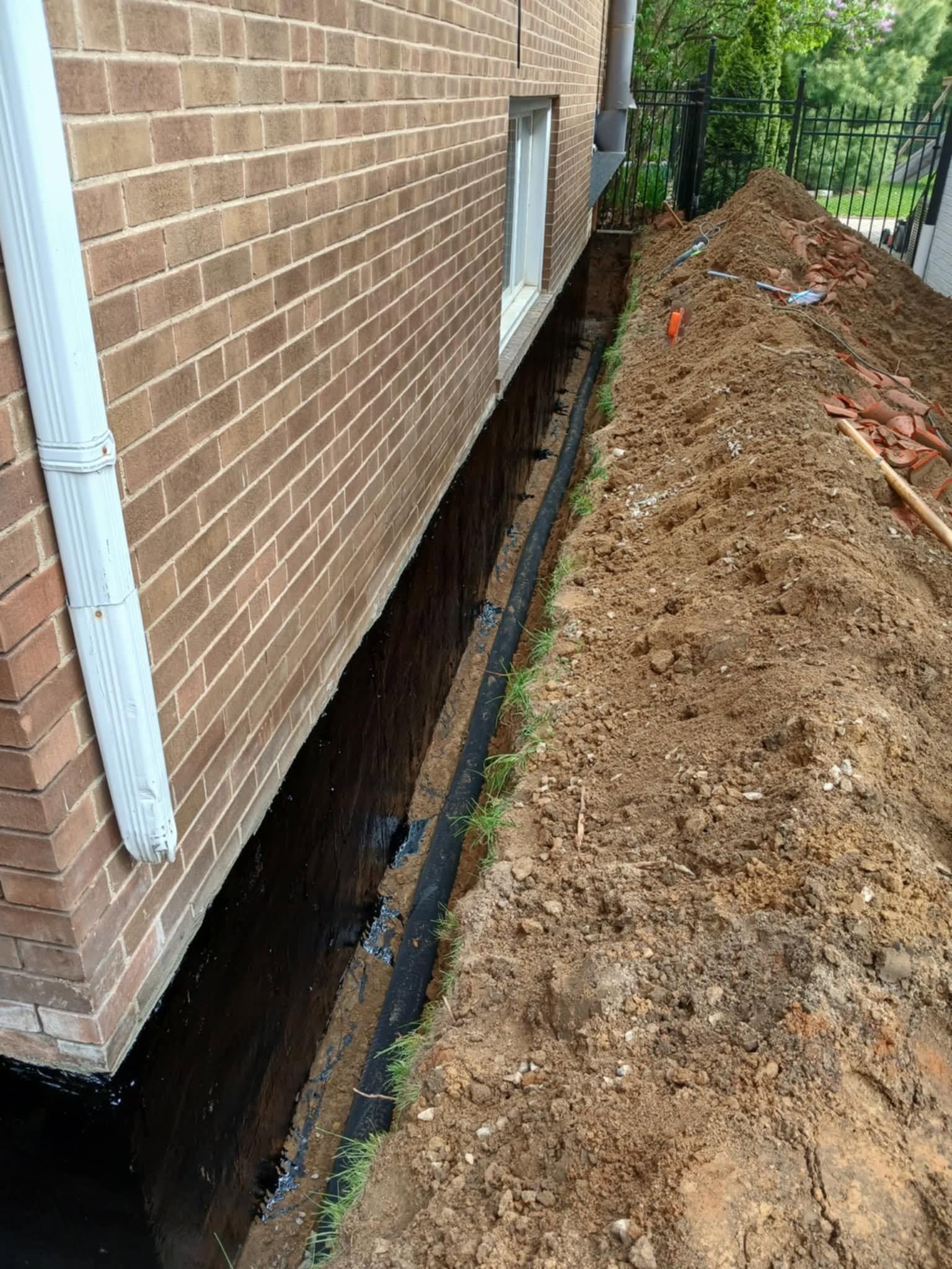Interior basement wall finished with dimpled waterproofing membrane