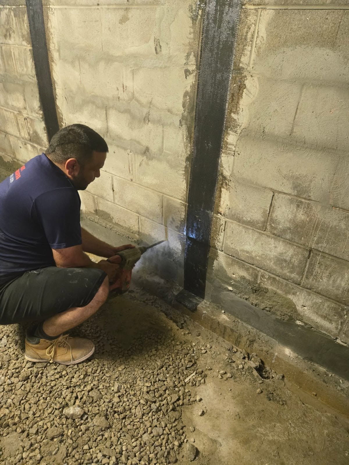 Rhino Inside Outside Waterproofing technician sealing a foundation crack inside a basement