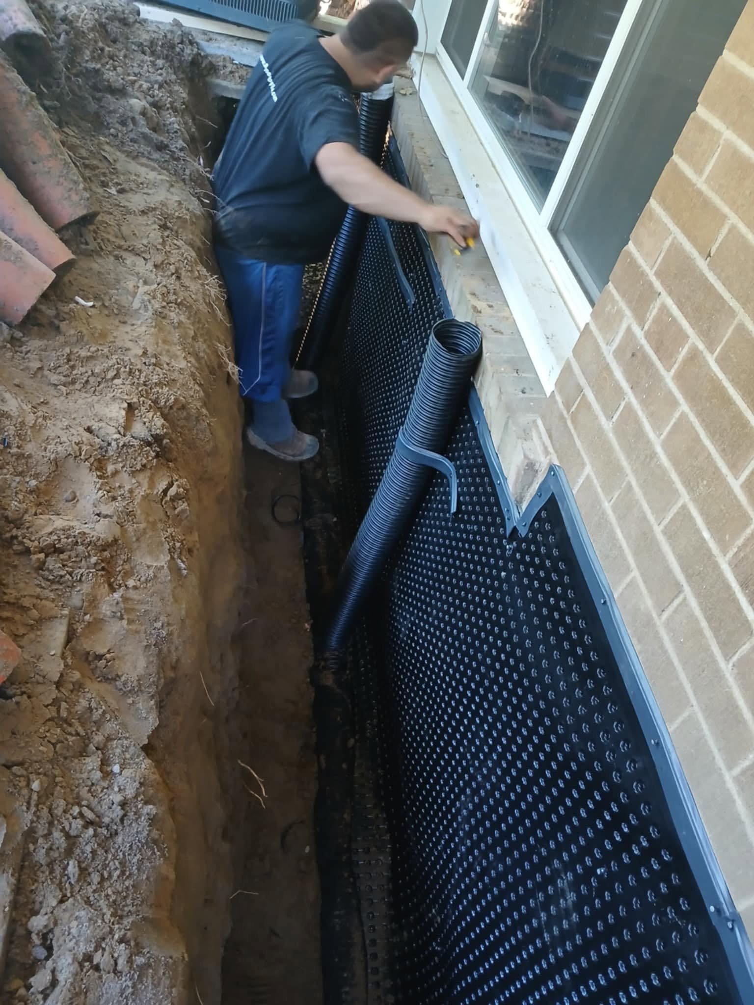 Rhino Inside Outside Waterproofing crew installing exterior foundation waterproofing membrane