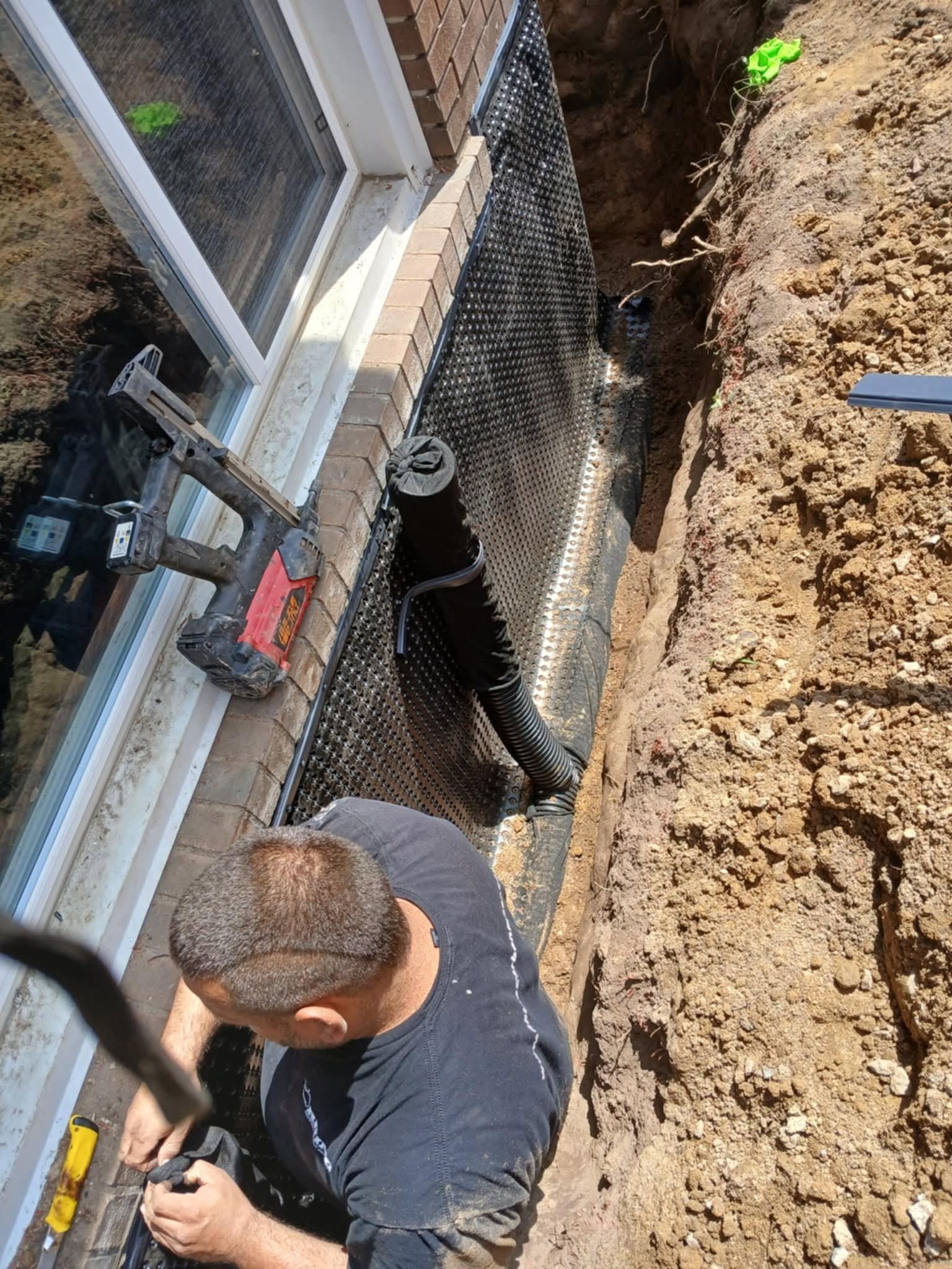 Foundation wall crack exposed in an excavated trench before underpinning repair